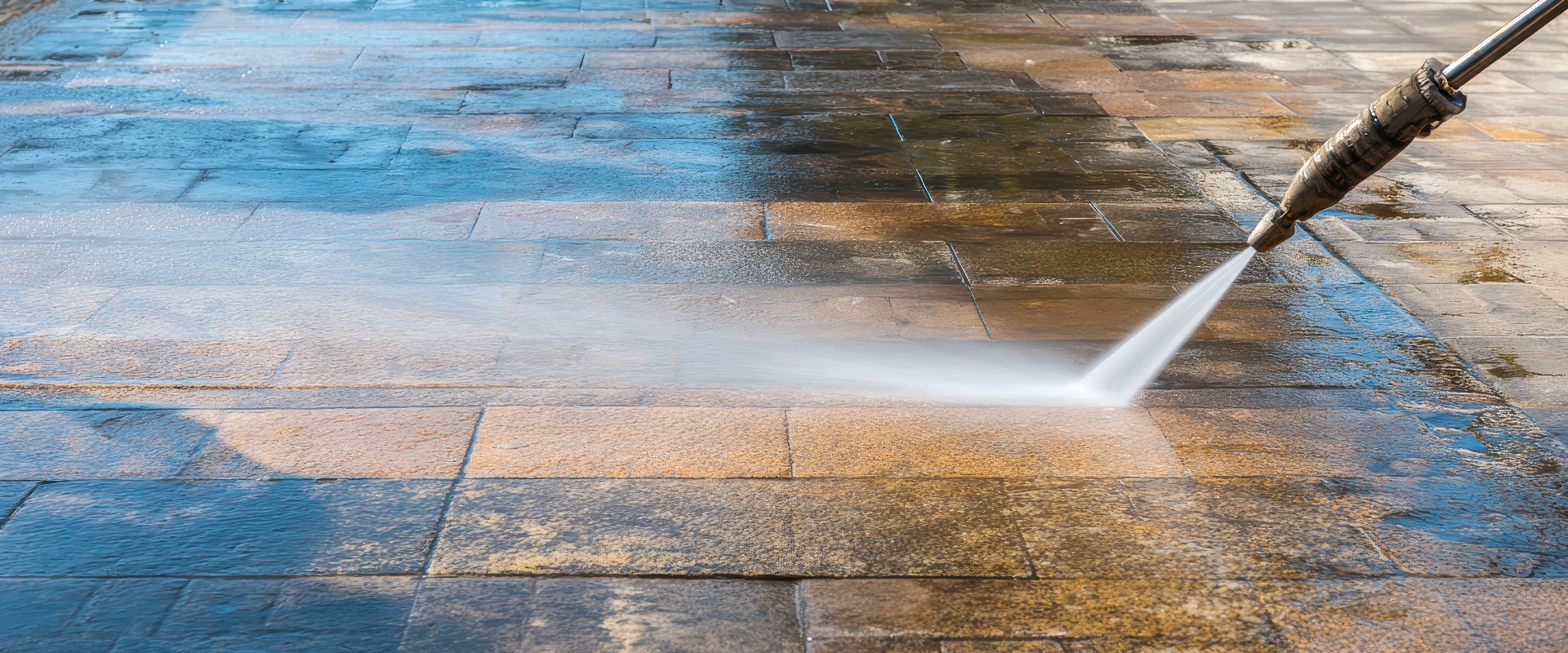 Hochdruckreinigung der Terrassenoberfläche zur gründlichen Reinigung und Aufarbeitung in sonniger Außenumgebung mit einem Hochdruckwasserstrahl